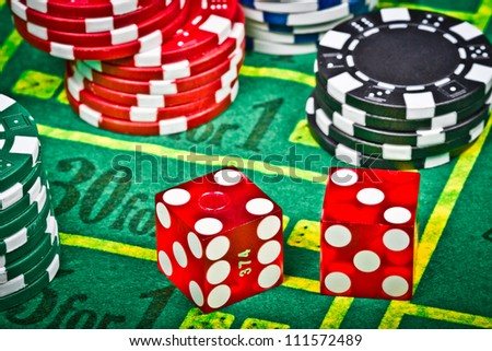 Two dices with seven over a green table with chips