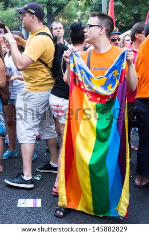 MADRID, SPAIN - JULY, 6: Unidentified man carries a rainbow flag at the Gay Pride parade on July 6, 2013 in Madrid (Spain). Near 1,200,000 people participated at the Gay Pride Parade in Madrid.
