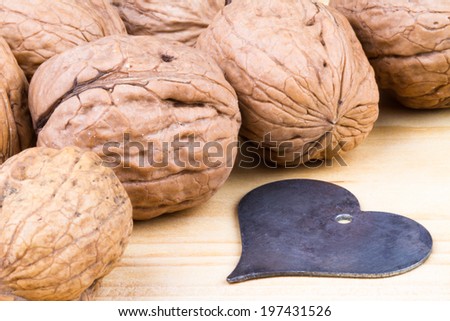 whole walnuts on rustic old wooden table with a heart