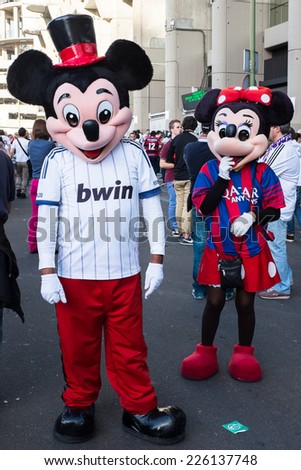 MADRID, SPAIN - OCTOBER 25, 2014: A couple of Mickey and Minnie Mouse with Real Madrid and Barcelona shirts, walking around Santiago Bernabeu Stadium at the Real Madrid-Barcelona match.