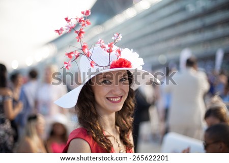 Beautiful girl wearing Sakura flower hat smiling at the Dubai World Cup Horse Race