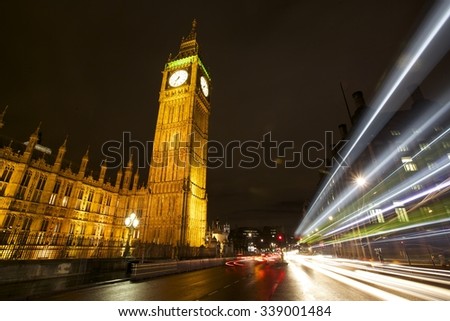 Busy Traffic Intersection at night with streaking car lights at the Houses of Parliament and Big Ben in London, England, United Kingdom