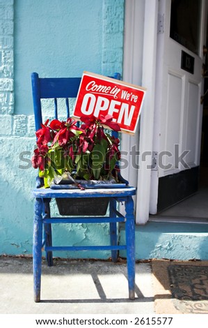We\'re Open sign on old blue chair