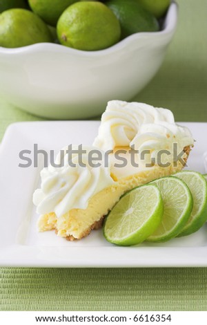 Slice of key lime pie with limes