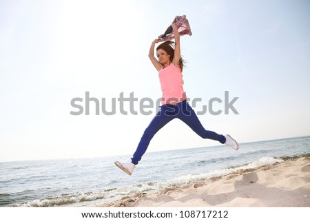 Happiness bliss freedom concept. Woman happy smiling joyful with arms up dancing on beach in summer during holidays travel. Beautiful young cheerful Caucasian female model