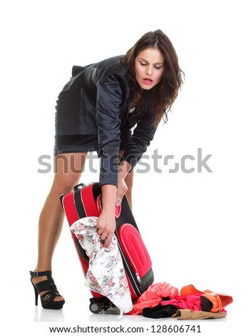Full length of young business woman to late mishap misadventure pulling red travel bag isolated on white background