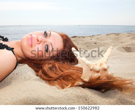The beautiful girl lies on sea coast with shells nature vacation woman