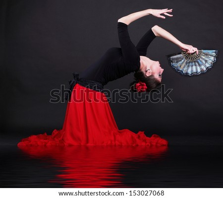Attractive spanish dancer over black background young woman dancing flamenco