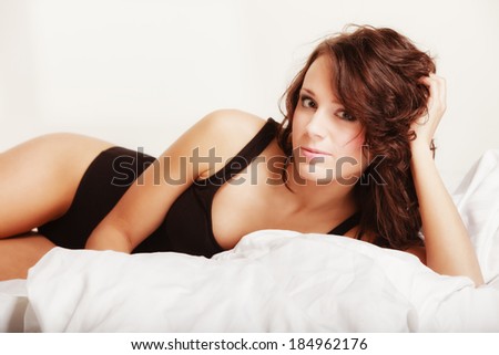 Sexy lazy girl lying on the bed. Young woman relaxing lazing in her bedroom at the morning.