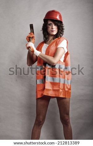 Sex equality and feminism. Sexy girl in safety helmet orange vest holding hammer tool. Attractive woman working as construction worker.