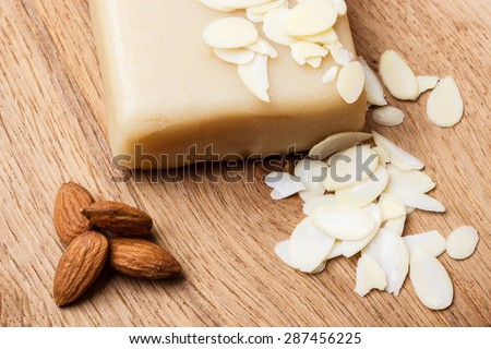 Whole food, good for health. Marzipan paste sliced blanched almonds and seeds on wooden kitchen board background