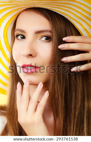 Holidays and summer fashion. Woman in big yellow hat and beauty manicure. Portrait of charming female on bright background.