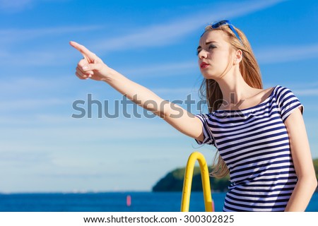 Young blonde woman casual style pointing with finger on sky background