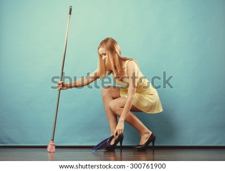 Cleanup housework concept. Elegant sensual woman sweeping wooden floor with broom.