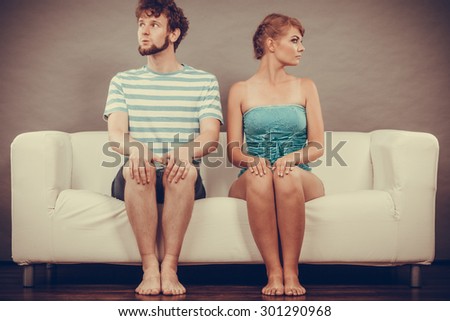 Bad relationship concept. Man and woman in disagreement. Young couple after quarrel sitting offended on couch at home