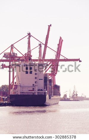 Business and commerce. Cranes and ships at port area, cargo container yard. Industrial scene
