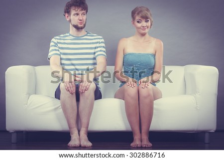 Relationship concept. Shy woman and man sitting close to each other on the couch.