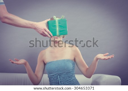 Male hand holding green gift box, man giving woman present, girl gesturing surprised unusual view filtered photo