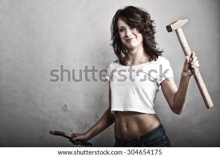 Sex equality and feminism. Sexy girl holding hammer and wrench spanner tools. Attractive woman working as repairman.