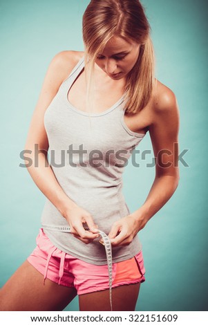 Weight loss, slim body, healthy lifestyle concept. Fit fitness woman in sportswear measuring perfect shape of her hips.
