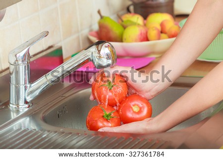 Woman hands washing fresh vegetables tomatoes in kitchen under water stream, preparation salad vegetarian meal