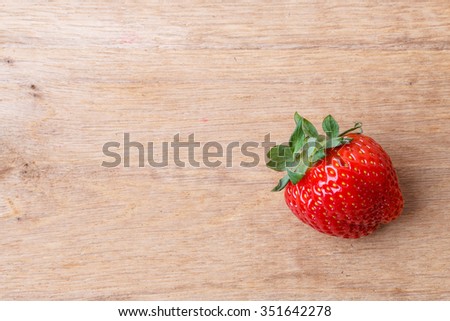 Healthy nutrition diet. Red fresh single strawberry fruit on wooden table board copy space text area