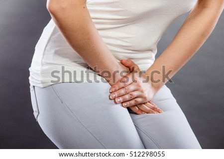 Young sick woman with hands holding pressing her crotch lower abdomen. Medical or gynecological problems, healthcare concept