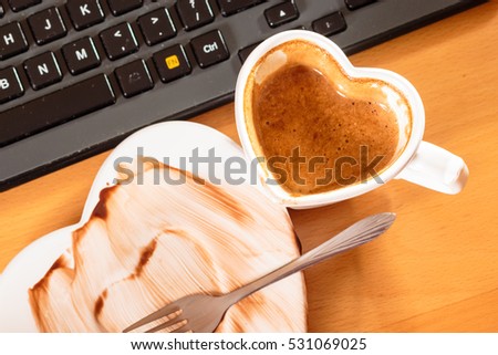 Closeup of heart shaped mug cup of coffee and dirty saucer plate. Top view.