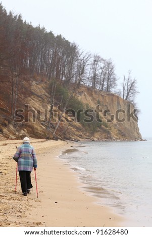 Nordic walking woman - autumn baltic sea cliff in Orlowo, Gdynia Poland