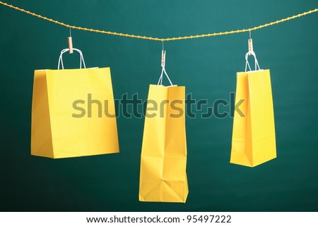 Shopping yellow gift bags on green background