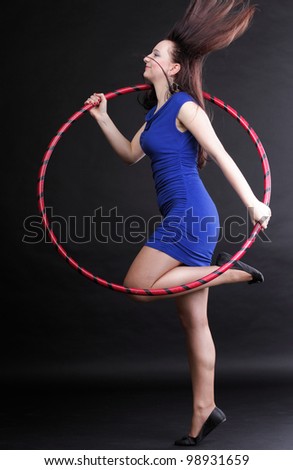 Beautiful woman in a sport wear. Dance hoop gym exercises black background