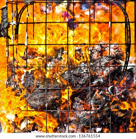 Fire with flames and remains of a burning container