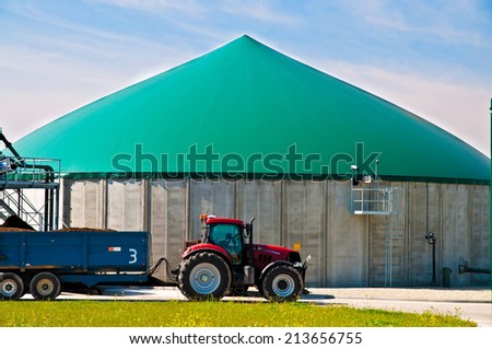 Red tractor in front of a biogas plant