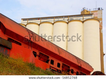Train wagon in front of a concrete silo battery