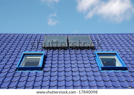 Blue tiles on a roof with window and solar energy recovery