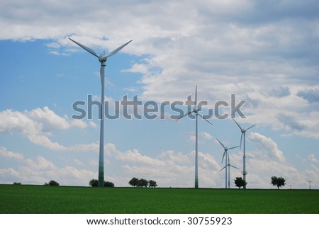 Wind energy towers with trees on a field