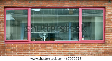 Office window with shutter and air blower in a brickstone building