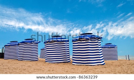 Blue and white striped tents on a beach in France