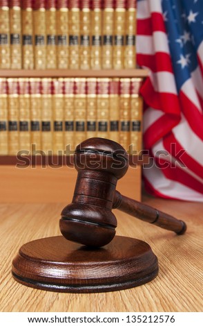Judge gavel with legal books and American flag in the background