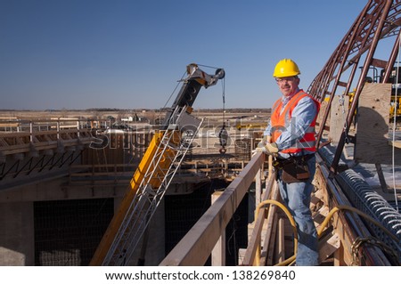 bridge construction worker by heavy construction equipment