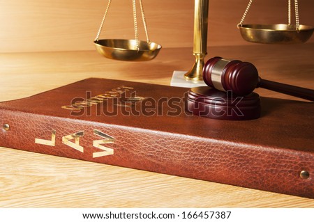 Justice gavel on Law book with scales of Justice in the background