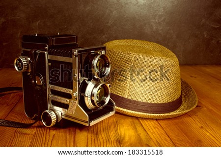 Old vintage camera with photographer fedora hat