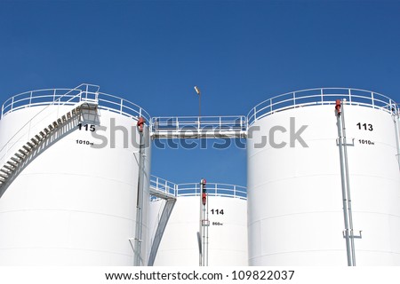 Tall white oil storage tanks