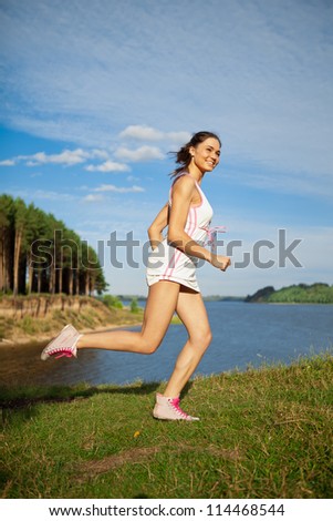 Running girl on the bank of river