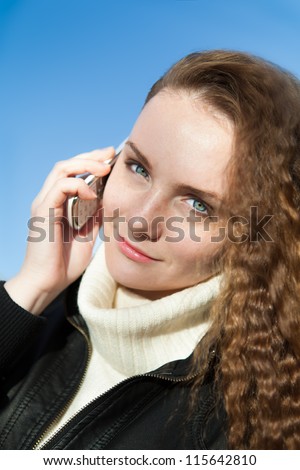 beautiful girl with bright blue eyes talk on the telephone