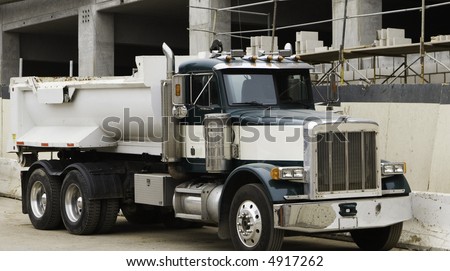 This truck is shown at the site of  a parking garage under construction