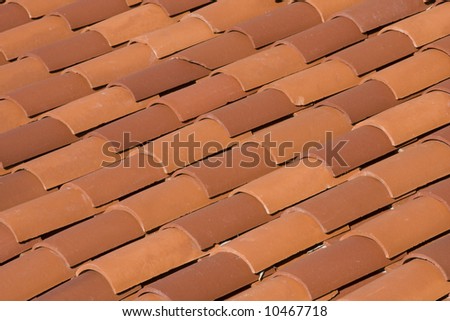 The diagonal pattern of red tiles on a roof.