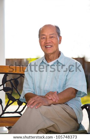 Happy Smiling Chinese Senior Elderly Sitting at Backyard