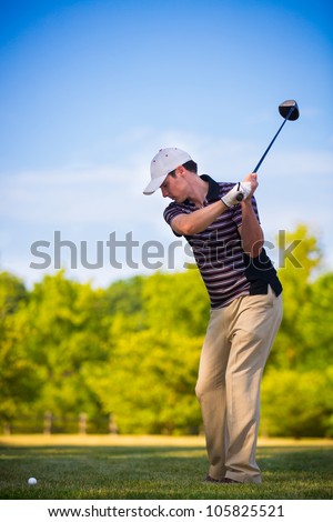 Young Golfer Swing Club under Summer Blue Sky