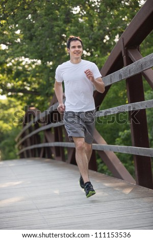 Jogging Healthy Looking Young Man Cross Bridge Under Morning Sunlight